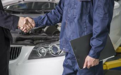 auto repair mechanic shaking hands with a client 